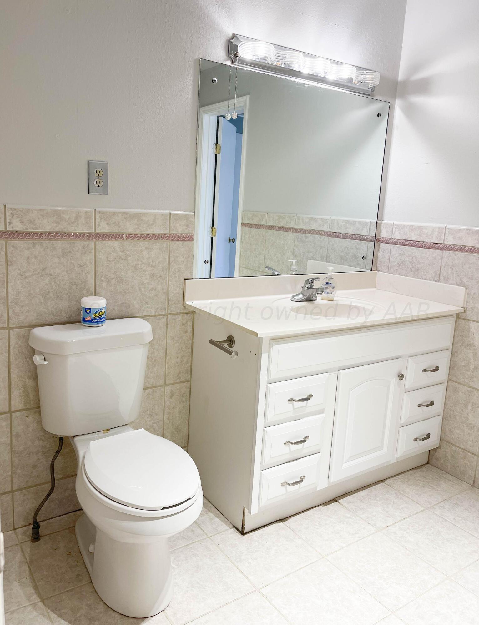 3707 Lynette Drive Amarillo, TX 79109 - Photo 34 of 45 a bathroom with a granite countertop toilet sink and mirror