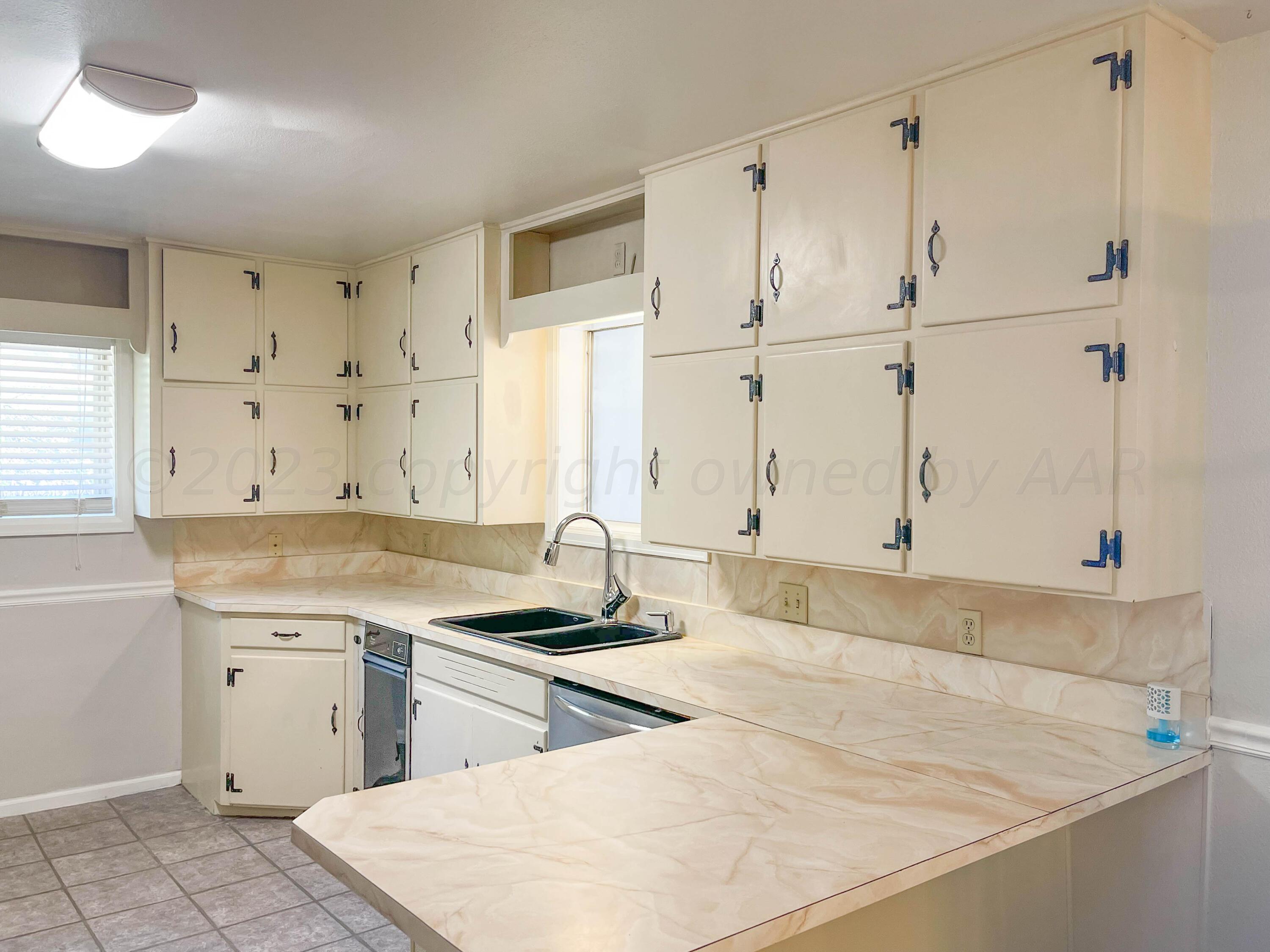 3707 Lynette Drive Amarillo, TX 79109 - Photo 9 of 45 a kitchen with granite countertop a sink cabinets and stainless steel appliances