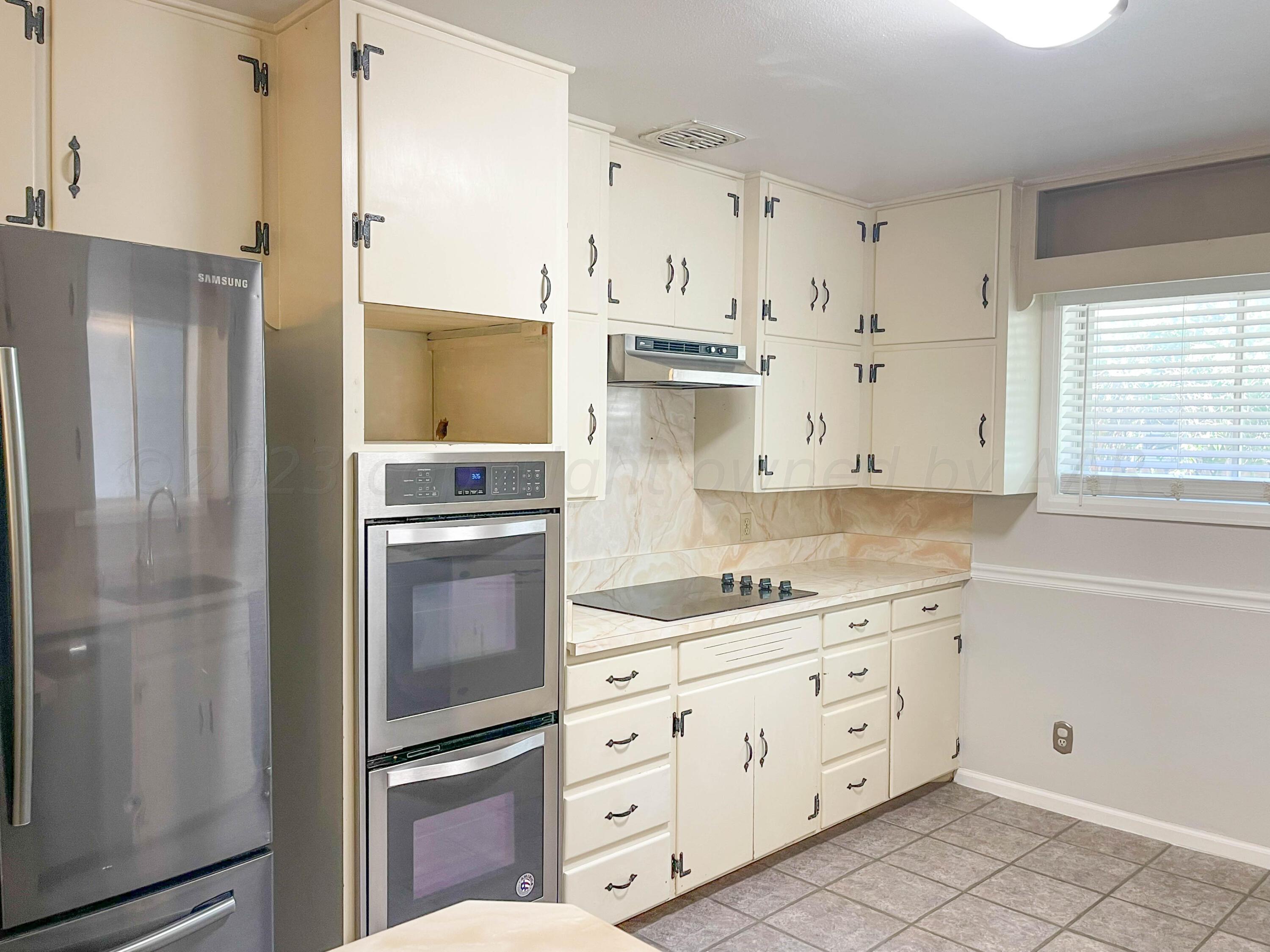 3707 Lynette Drive Amarillo, TX 79109 - Photo 10 of 45 a kitchen with cabinets stainless steel appliances and a window