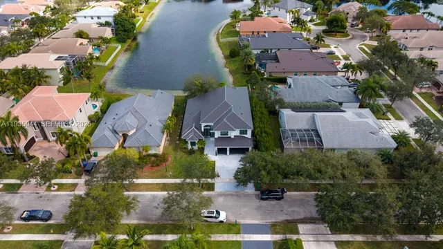 an aerial view of a city with lots of residential buildings ocean and mountain view in back