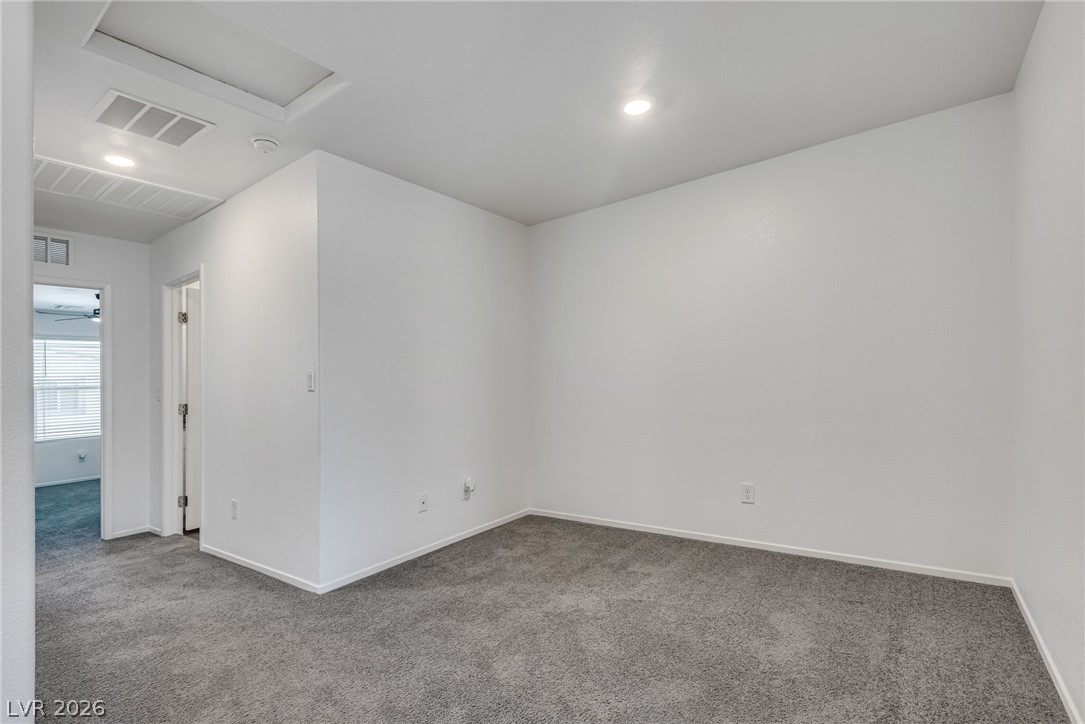 1114 Scarlet Sparrow Street Henderson, NV 89011 - Photo 20 of 25 A well-lit room offers versatility for various uses, featuring recessed lighting and plush carpeting.