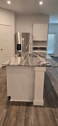a kitchen with kitchen island a counter top a sink and a stove