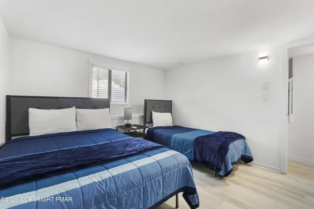 a bedroom with two beds and painting on the wall