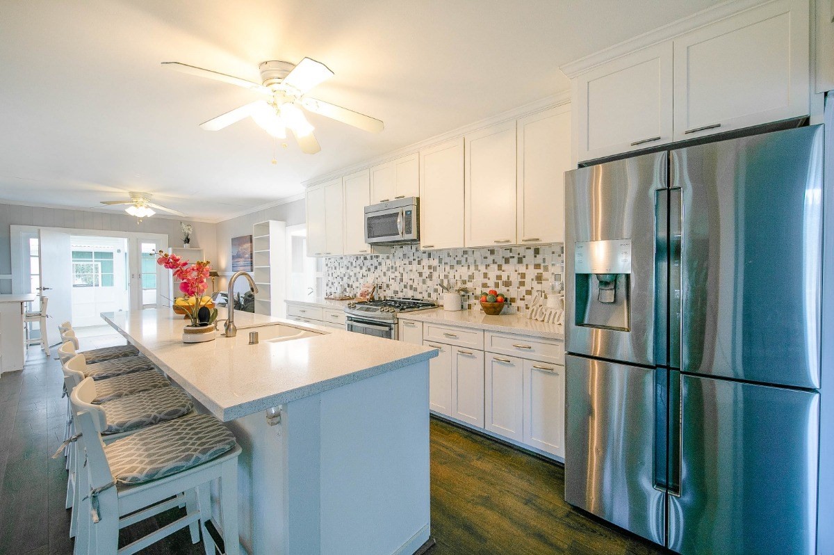 4368 Omao Road Koloa, HI 96756 - Photo 9 of 30 a kitchen with kitchen island a sink appliances and cabinets