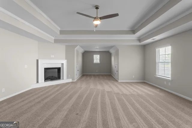 an empty room with windows and fireplace