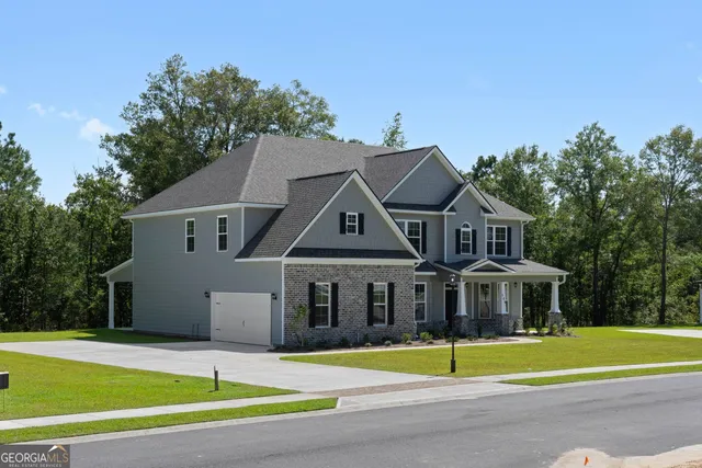 a front view of a house with a yard and trees