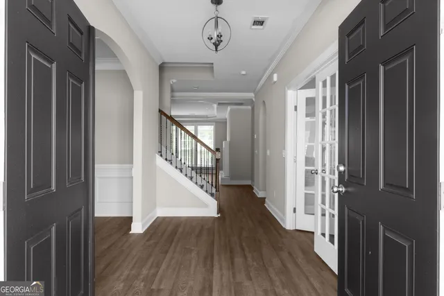 a view of a hallway with wooden floor and staircase