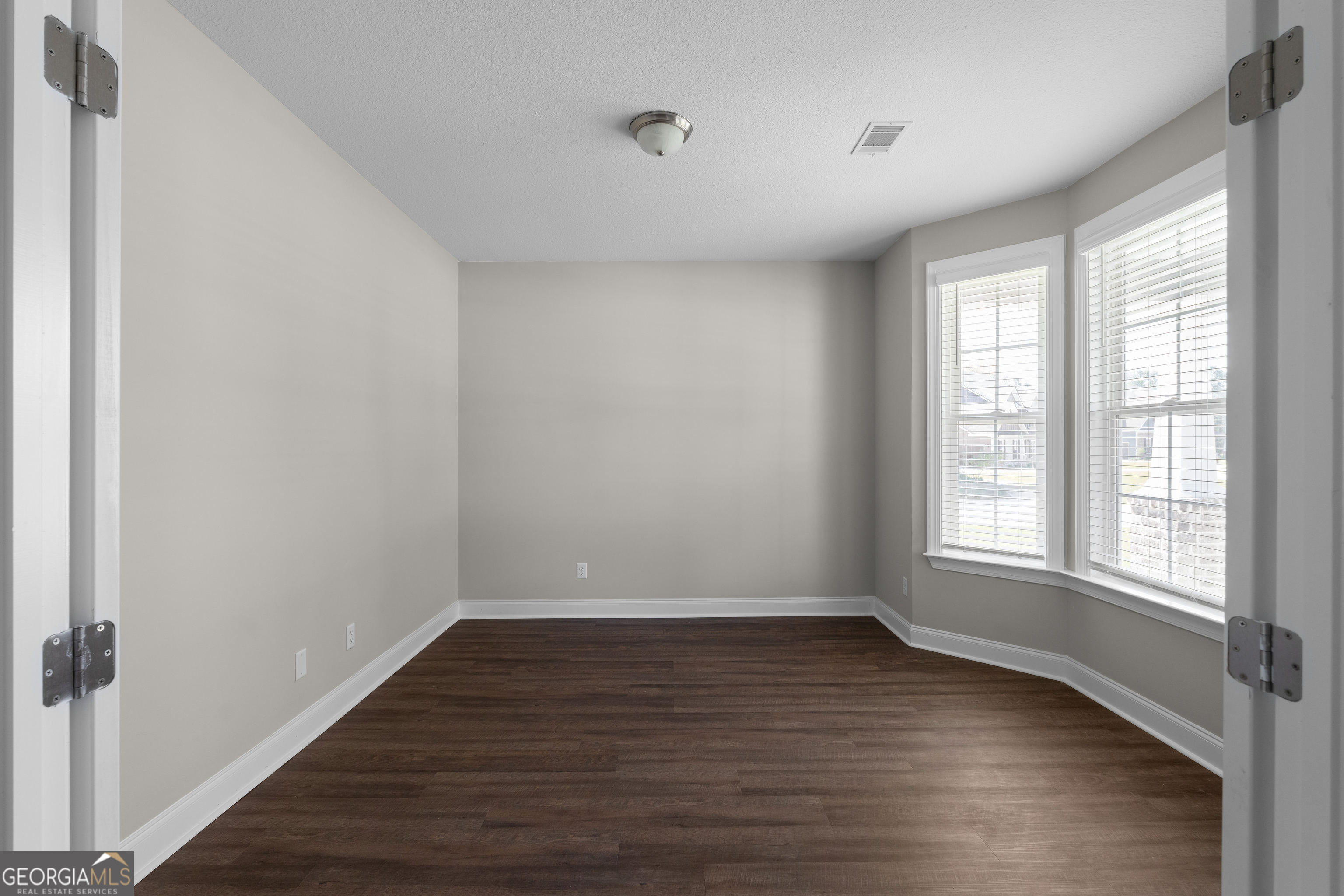 140 Watson Mill Road Guyton, GA 31312 - Photo 8 of 32 a view of an empty room with wooden floor and a window