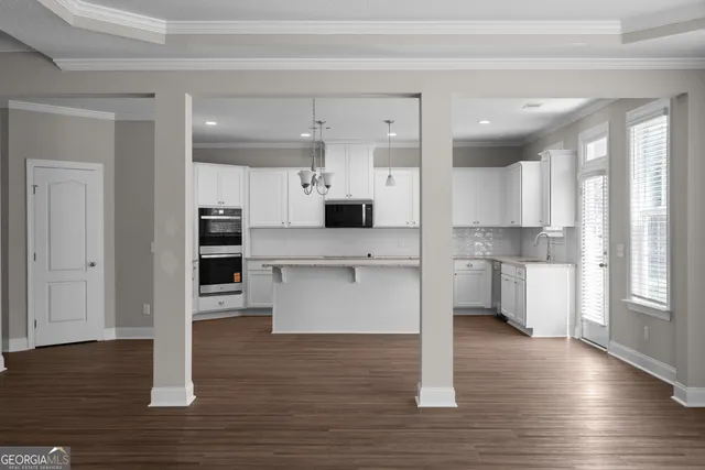 a view of kitchen with wooden floor and electronic appliances