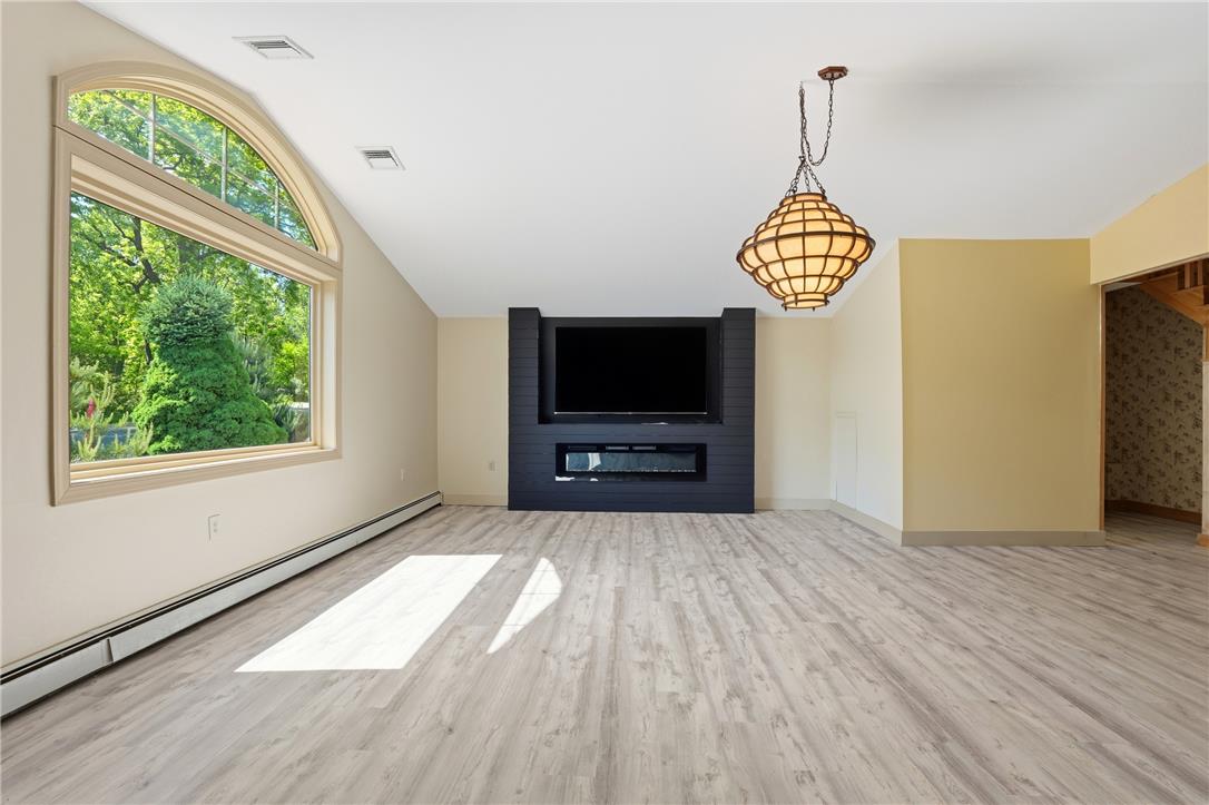 6271 Batman Road Zionsville, PA 18092 - Photo 25 of 100 A spacious living area with wood flooring and a prominent arched window and fireplace.