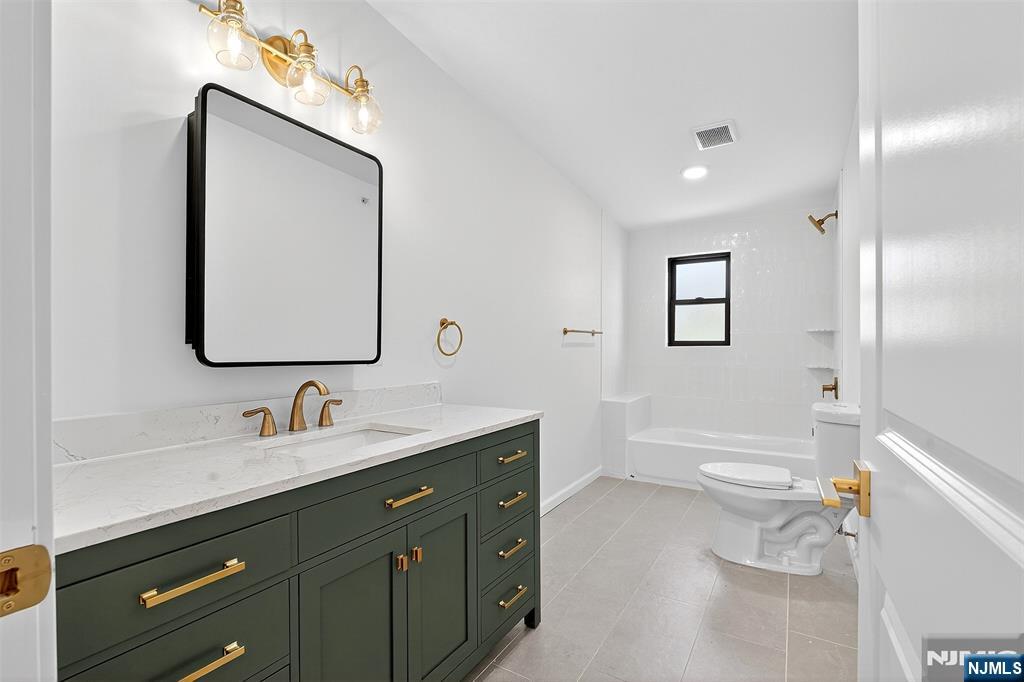 167 Harrison Avenue, Unit 3 Montclair, NJ 07042 - Photo 15 of 20 a bathroom with a toilet a sink a bathtub and a mirror
