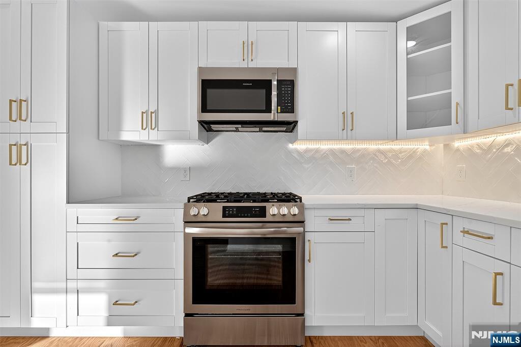 167 Harrison Avenue, Unit 3 Montclair, NJ 07042 - Photo 3 of 20 a kitchen with stainless steel appliances white cabinets and a stove top oven