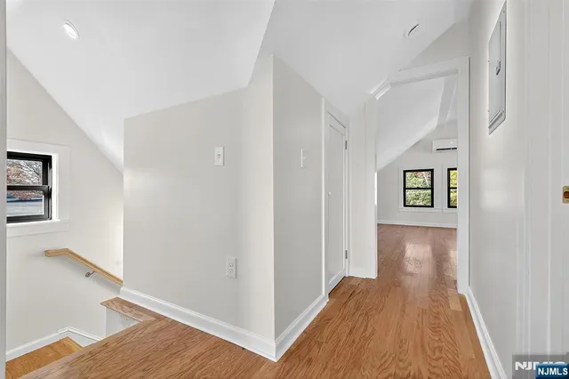 a view of a hallway with wooden floor and closet