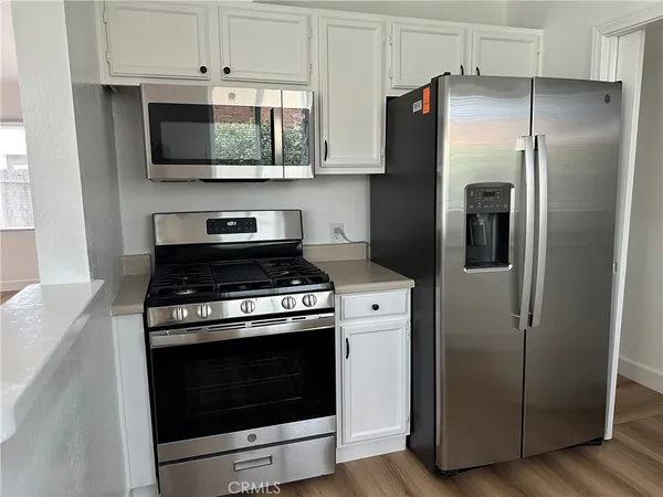 a kitchen with stainless steel appliances wooden floor sink and granite counter tops