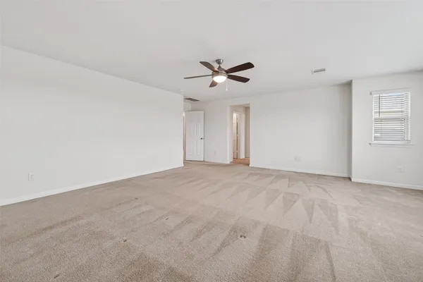 an empty room with a window and a fan