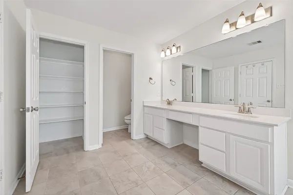 an empty room with closet and a chandelier fan