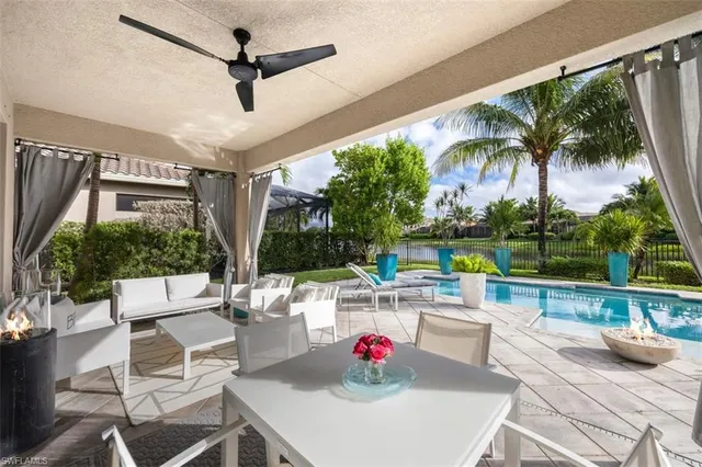 a living room with patio furniture and a floor to ceiling window