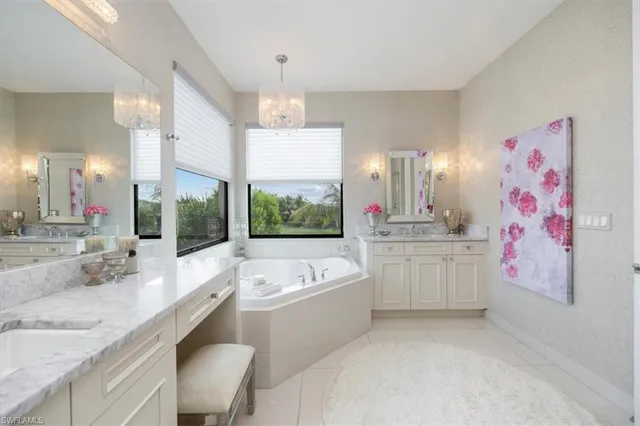 a bathroom with a granite countertop sink a large mirror and a bathtub