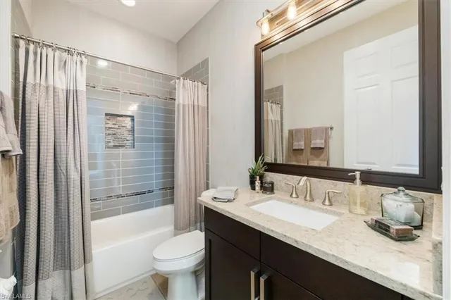 a bathroom with a granite countertop sink toilet and shower