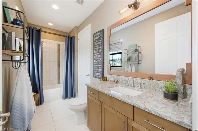 a bathroom with a granite countertop sink a toilet a mirror and shower