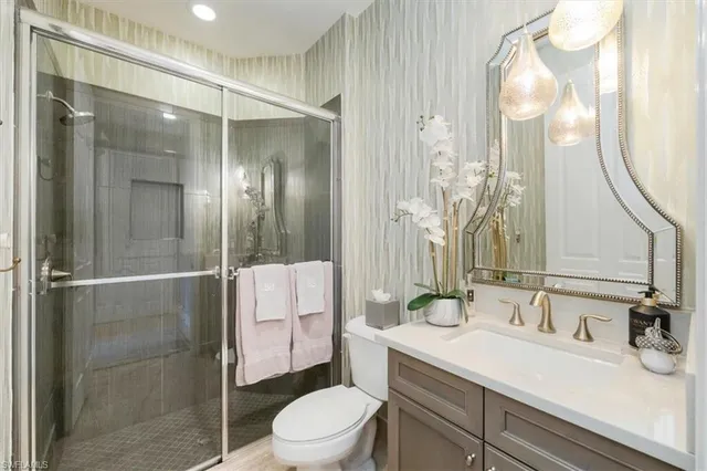 a bathroom with a sink vanity granite toilet and shower