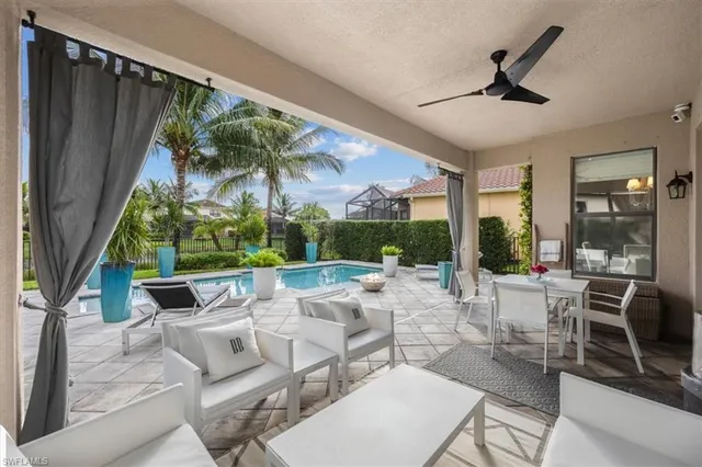 a living room with patio furniture and a large window