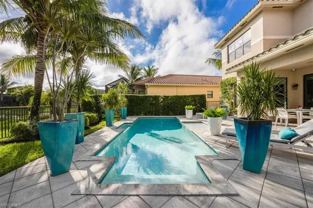 a view of a swimming pool with a patio and a garden