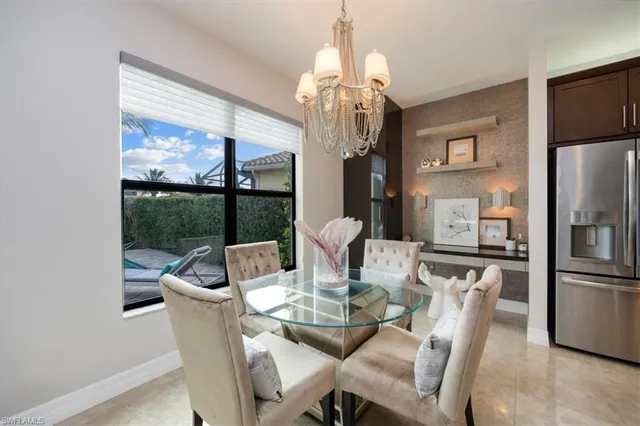 a dining room with furniture a large window and kitchen view