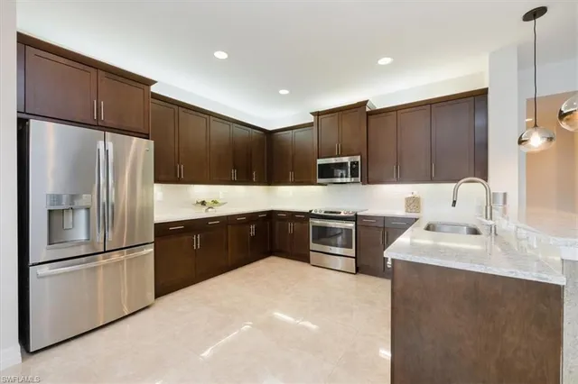 a large kitchen with cabinets stainless steel appliances and a sink
