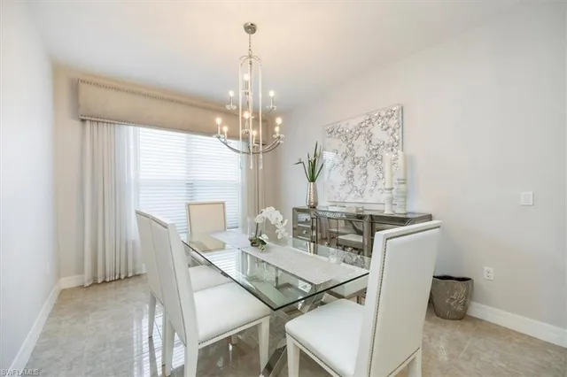 a view of a dining room with furniture a chandelier and window