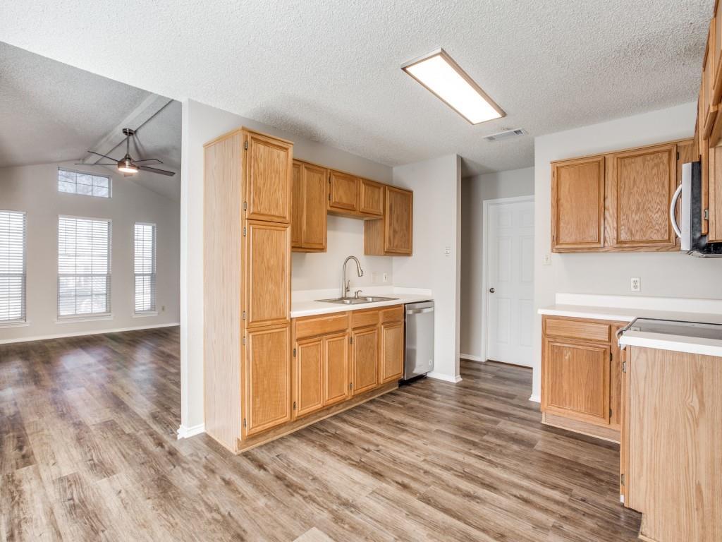 2097 Quarter Horse Lane Keller, TX 76248 - Photo 6 of 16 a kitchen with stainless steel appliances granite countertop a sink cabinets and wooden floor