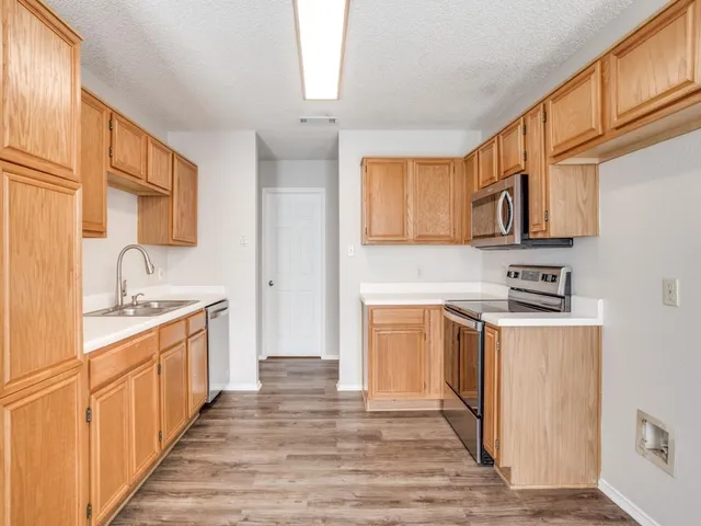 a kitchen with stainless steel appliances granite countertop a sink stove and cabinets