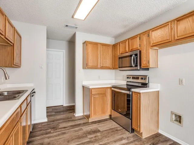 a kitchen with stainless steel appliances granite countertop a stove a sink and a refrigerator