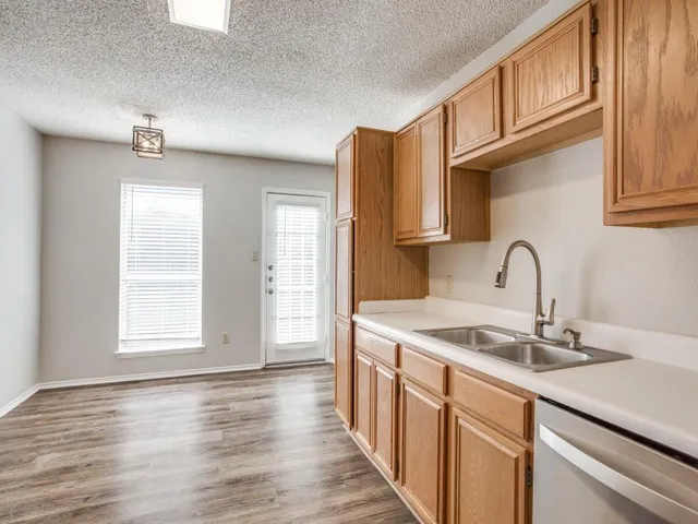 a kitchen with stainless steel appliances granite countertop a sink and dishwasher with wooden floor