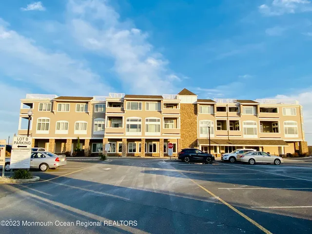 a front view of a building with lot of cars
