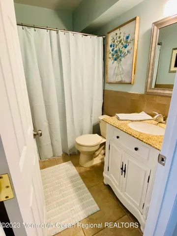 a bathroom with a sink a toilet and a shower curtain