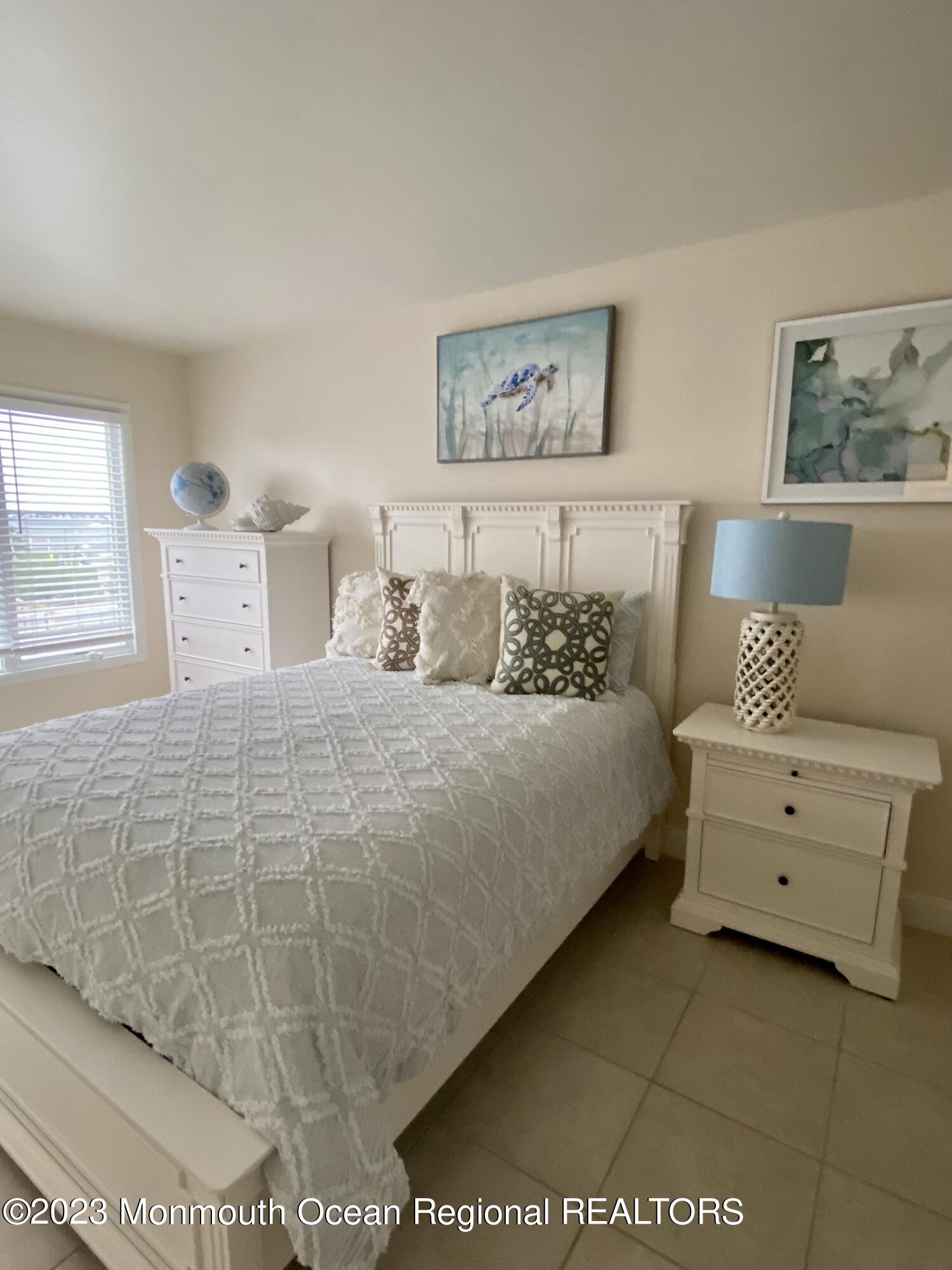 438 Highway 35, Unit 5305 Mantoloking, NJ 08738 - Photo 15 of 19 a bedroom with a bed and a night stand