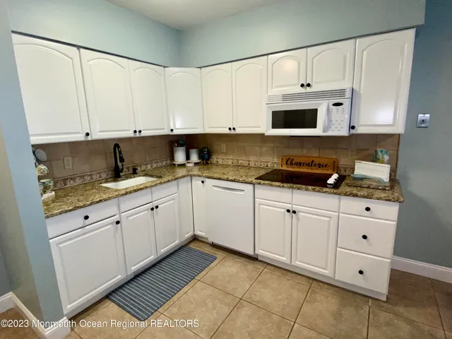 a kitchen with cabinets stainless steel appliances and a sink