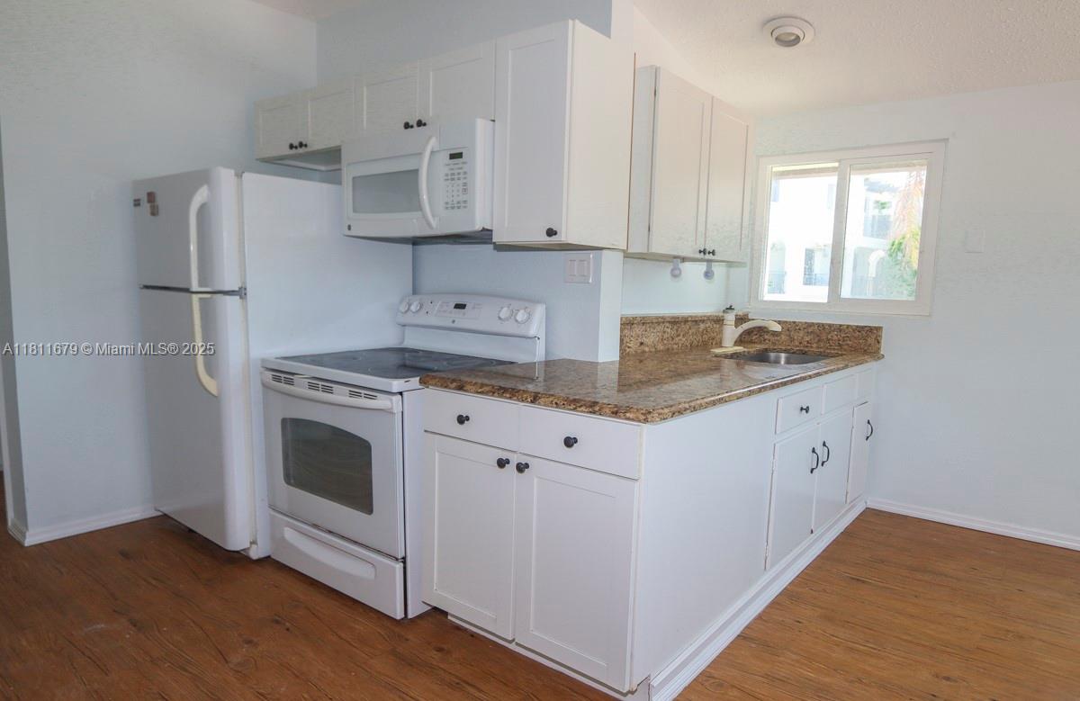 812 Chukker Road, Unit 3 Delray Beach, FL 33483 - Photo 14 of 20 a kitchen with cabinets appliances and wooden floor