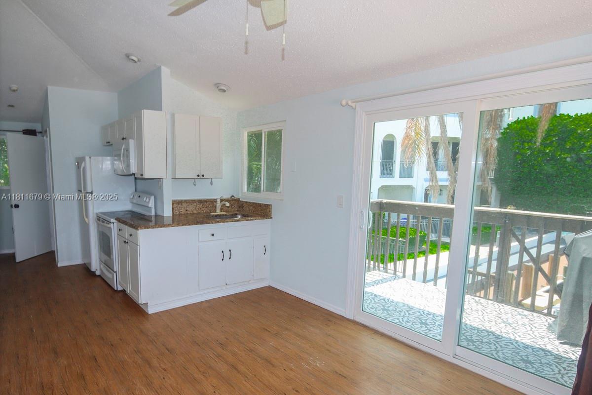 812 Chukker Road, Unit 3 Delray Beach, FL 33483 - Photo 6 of 20 a kitchen with white cabinets and wooden floor