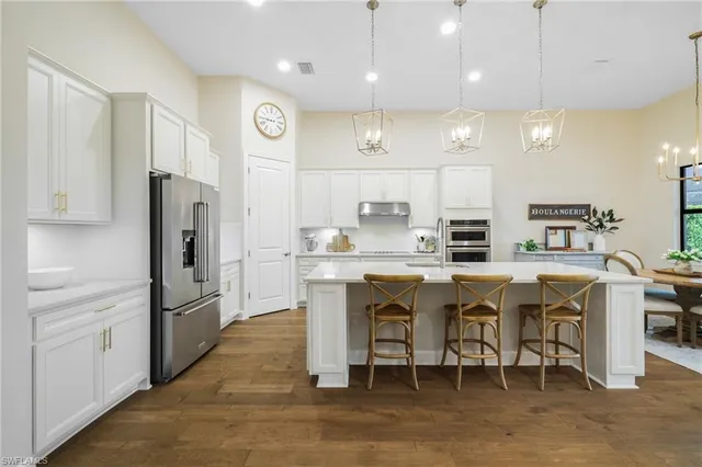 a kitchen with stainless steel appliances granite countertop a sink a stove and a wooden floors