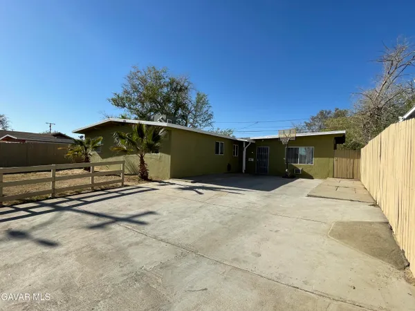 a view of a house with backyard and parking