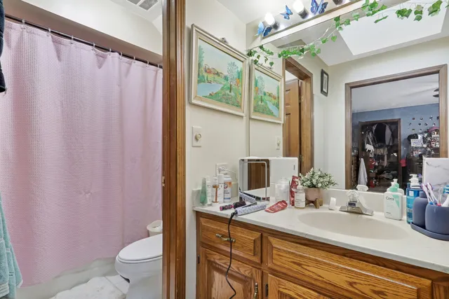 a bathroom with a double vanity sink toilet and shower
