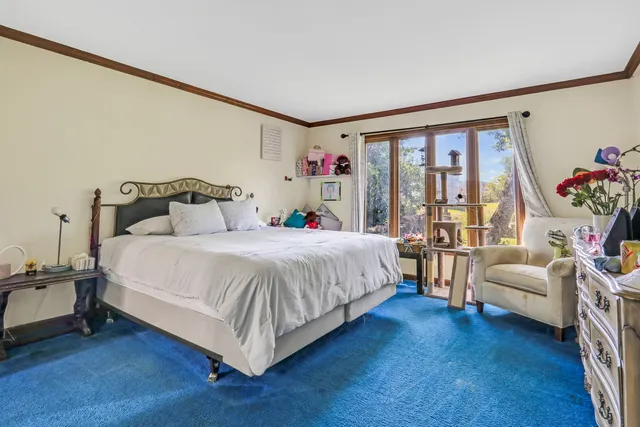 a bed sitting in a bedroom next to a large window