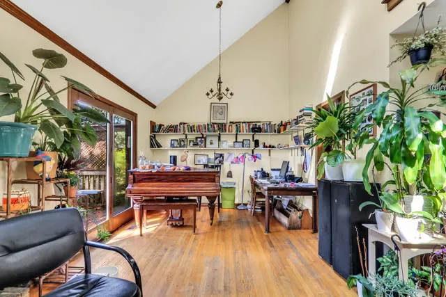 a living room with furniture a piano and a potted plant