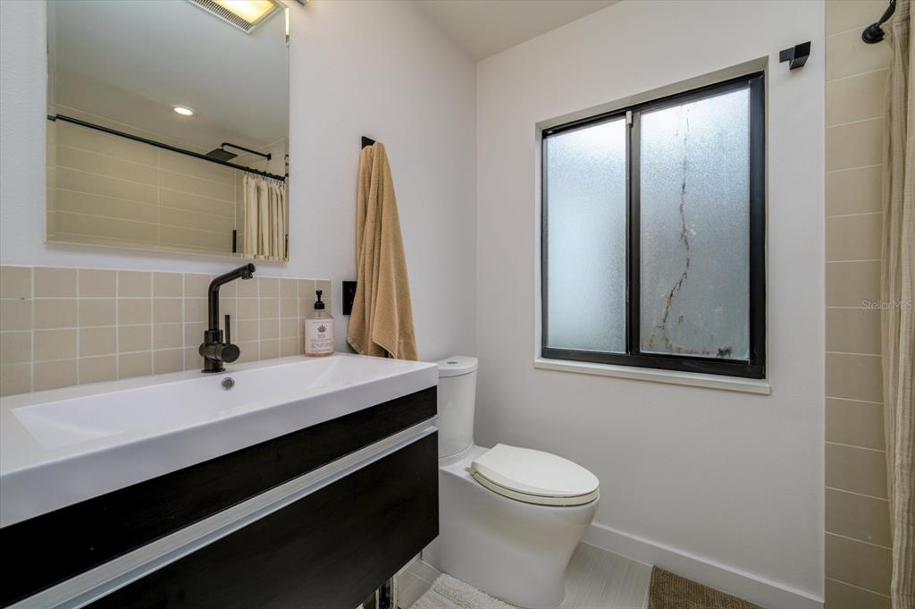 29318 Whippoorwill Lane Wesley Chapel, FL 33543 - Photo 19 of 38 a bathroom with a sink a toilet and mirror