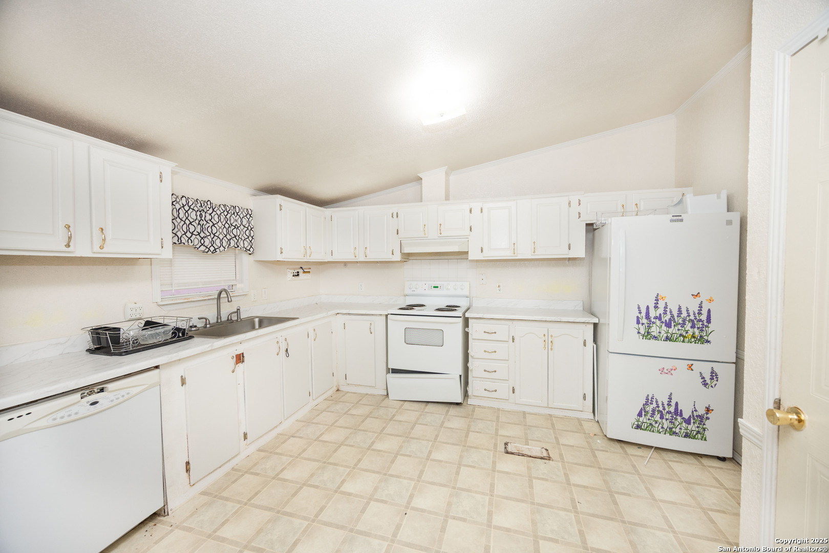 808 Uvalde Street Pleasanton, TX 78064 - Photo 9 of 25 a kitchen with white cabinets and white appliances