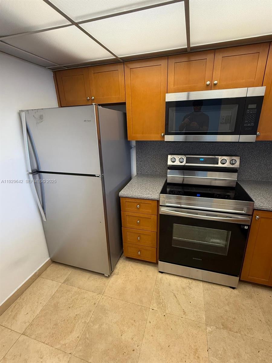 555 Northeast 15th Street, Unit 14K Miami, FL 33132 - Photo 13 of 47 a kitchen with a stove and a refrigerator