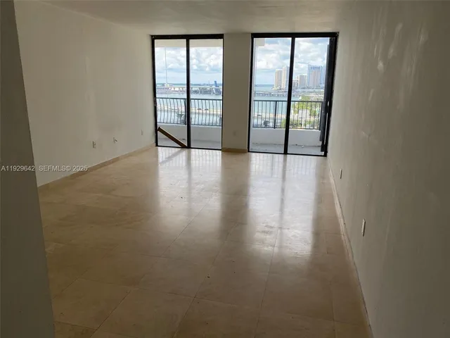 an empty room with a cabinet and mirrors