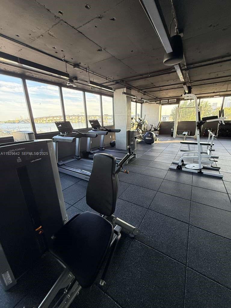 555 Northeast 15th Street, Unit 14K Miami, FL 33132 - Photo 39 of 47 a living room with patio furniture and a floor to ceiling window